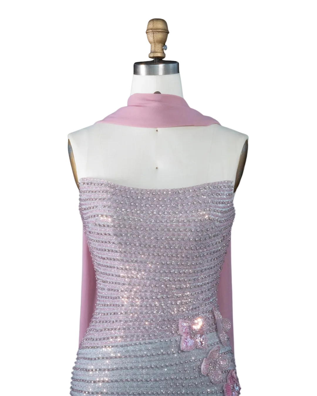 A mannequin torso wearing a pale pink draped scarf and a strapless lavender sequined dress with pink floral embellishments, shown against a light blue background. The text 'RIVIERA BOARD THE WARDA' appears in the top left corner.