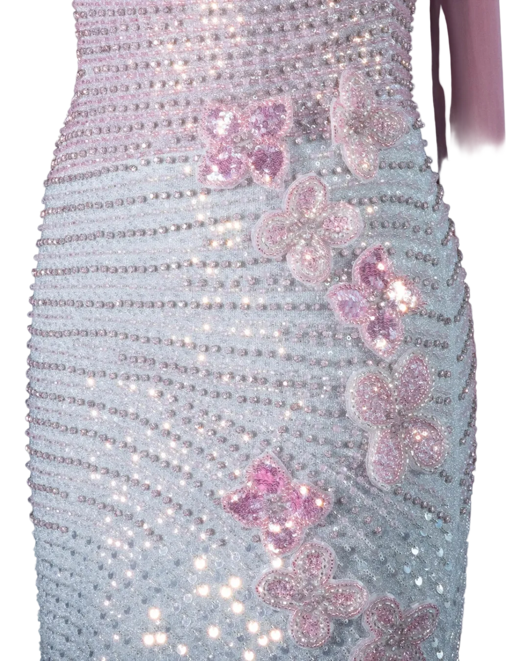 Close-up of a shimmering lavender and silver embellished dress with pink sequined flower appliqués, shown on a mannequin against a pale background.