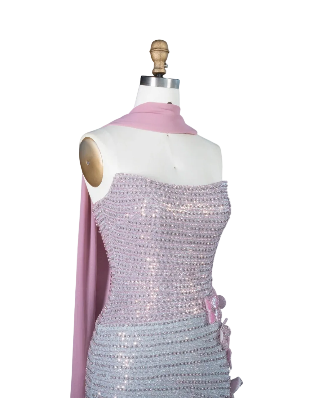A lavender sequined strapless dress displayed on a white mannequin torso with a pink scarf draped over the shoulders. The brand logo 'RIVIERA BOARD THE WANDA' is visible in the top left corner against a light blue background.