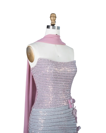 A lavender sequined strapless dress displayed on a white mannequin torso with a pink scarf draped over the shoulders. The brand logo 'RIVIERA BOARD THE WANDA' is visible in the top left corner against a light blue background.